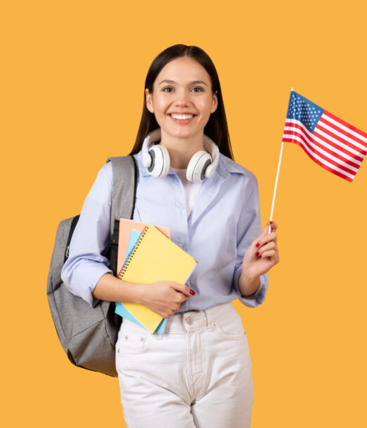 Radiant female student carrying notebooks and wearing headphones on her neck, holds American flag, embodying optimism and pursuit of knowledge against bright yellow background